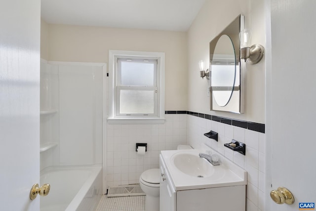 bathroom with toilet, vanity, tile walls, and tile patterned floors