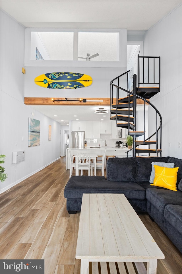 living room featuring hardwood / wood-style floors and ceiling fan