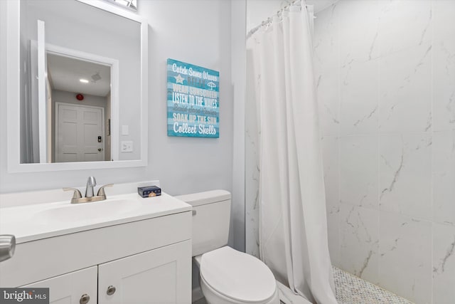 bathroom with curtained shower, vanity, and toilet