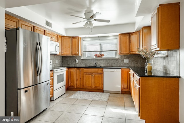 kitchen featuring sink, ceiling fan, light tile patterned floors, white appliances, and decorative backsplash