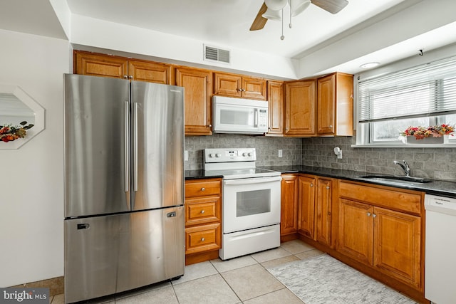 kitchen with decorative backsplash, sink, light tile patterned floors, ceiling fan, and white appliances