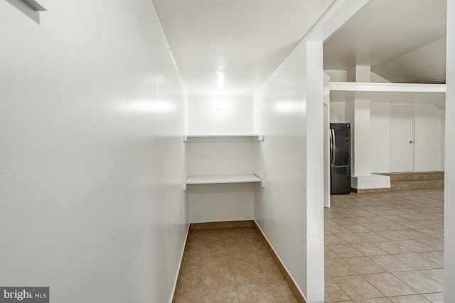 walk in closet with light tile patterned floors