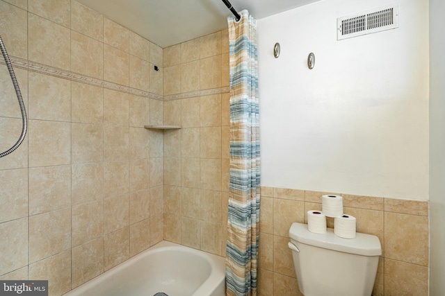 bathroom featuring tile walls, toilet, and shower / tub combo