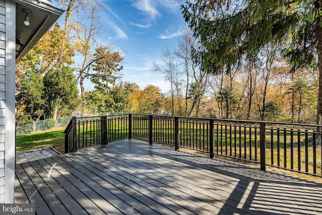 wooden deck featuring a lawn