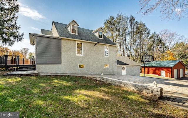 view of side of home with a lawn, a patio, a storage unit, and a deck