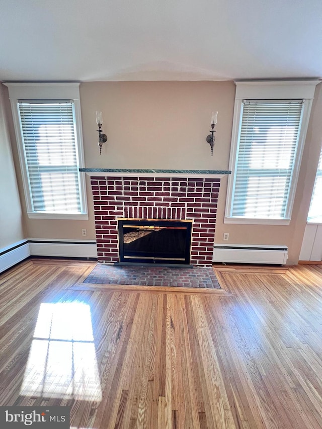 unfurnished living room featuring light hardwood / wood-style floors and baseboard heating