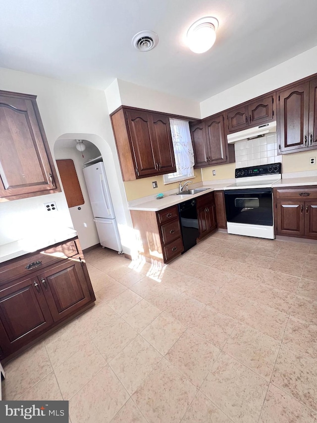 kitchen with dark brown cabinets, sink, and white appliances