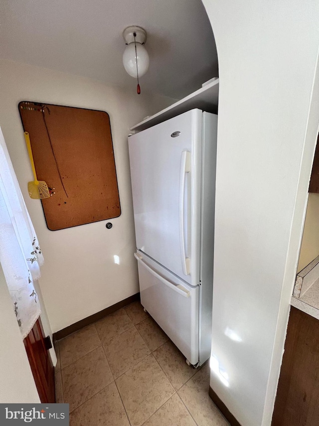 kitchen featuring light tile patterned floors and white fridge