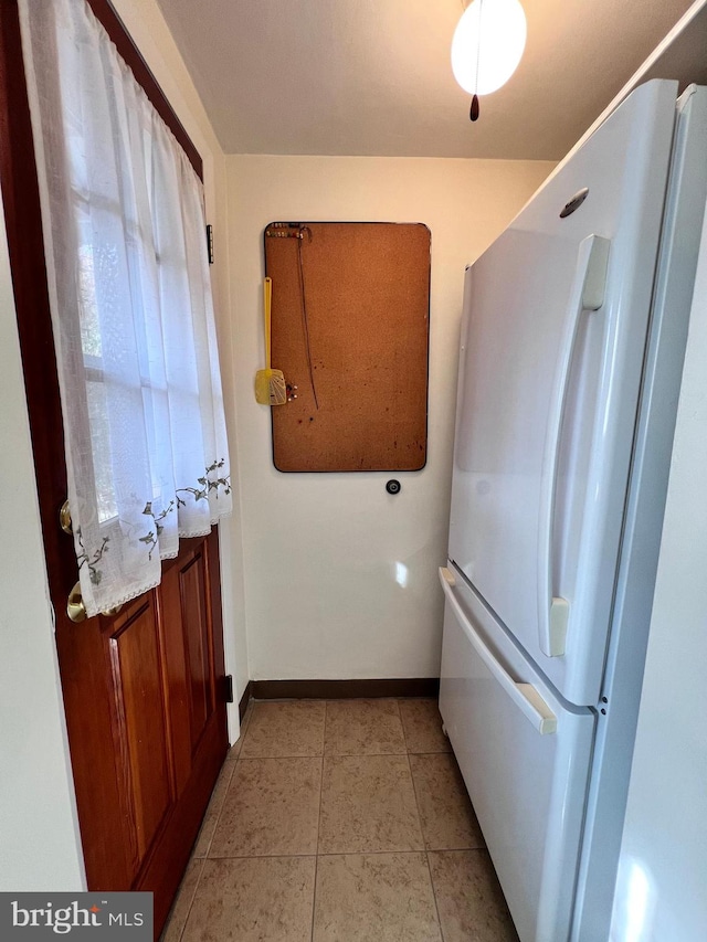 kitchen featuring light tile patterned floors and white fridge