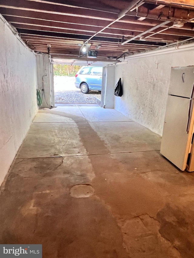 garage featuring a garage door opener and white fridge