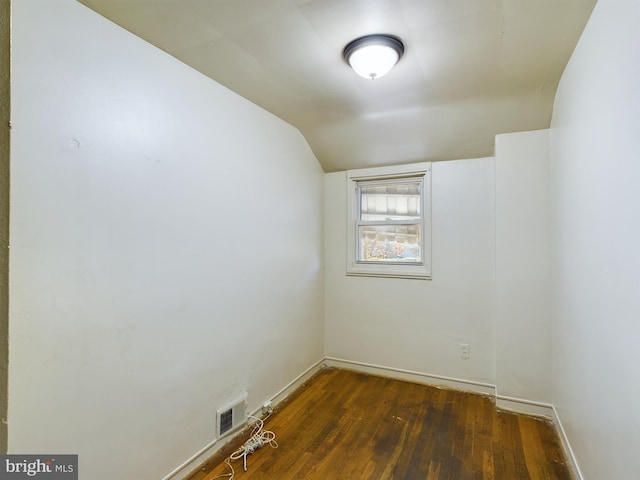 empty room with dark hardwood / wood-style floors and lofted ceiling