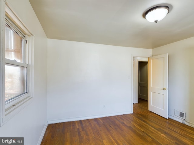 unfurnished room with dark wood-type flooring