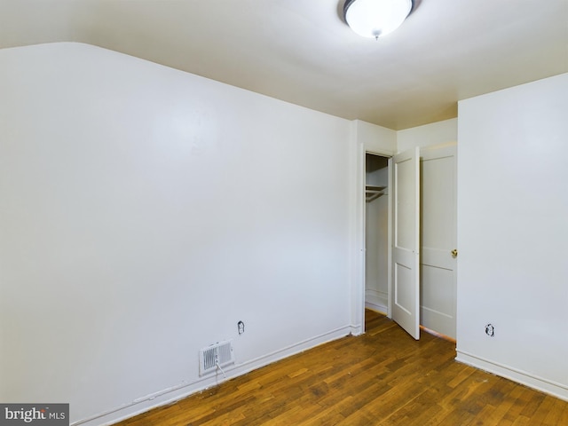 unfurnished bedroom featuring dark hardwood / wood-style flooring and a closet