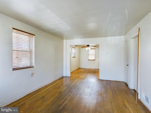 spare room with plenty of natural light, wood-type flooring, and ceiling fan