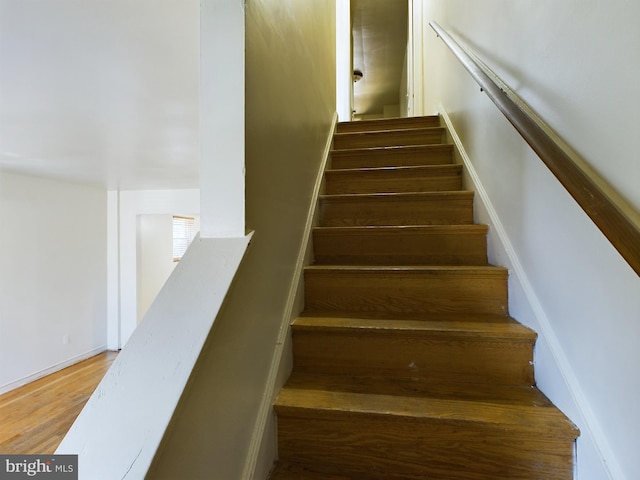 stairs featuring hardwood / wood-style floors