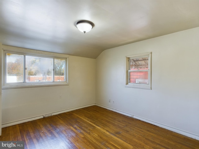 unfurnished room featuring dark hardwood / wood-style flooring and lofted ceiling