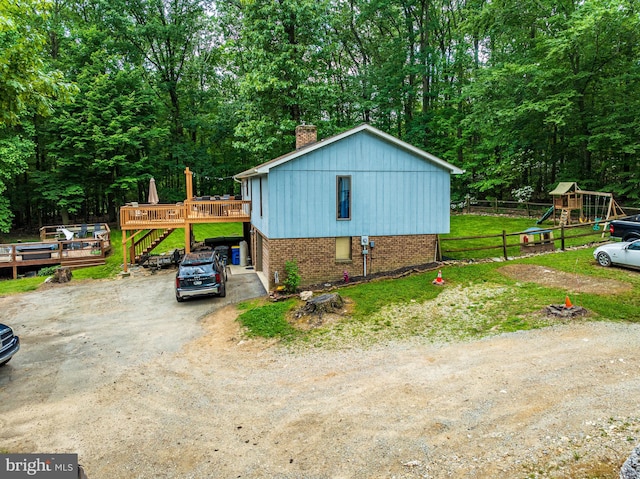 view of side of home featuring a playground and a wooden deck