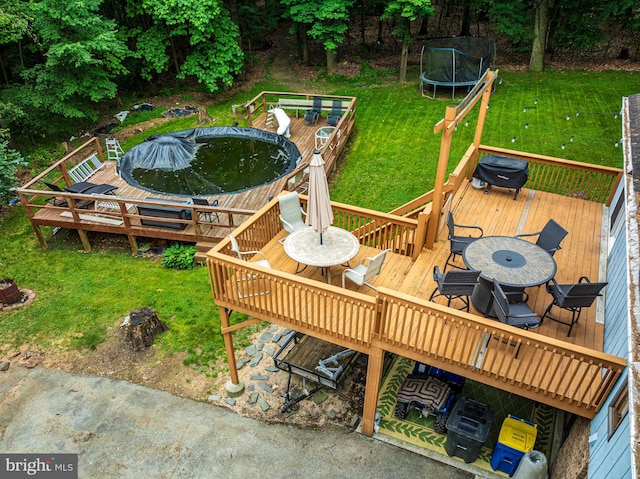 deck with area for grilling, a trampoline, and a lawn