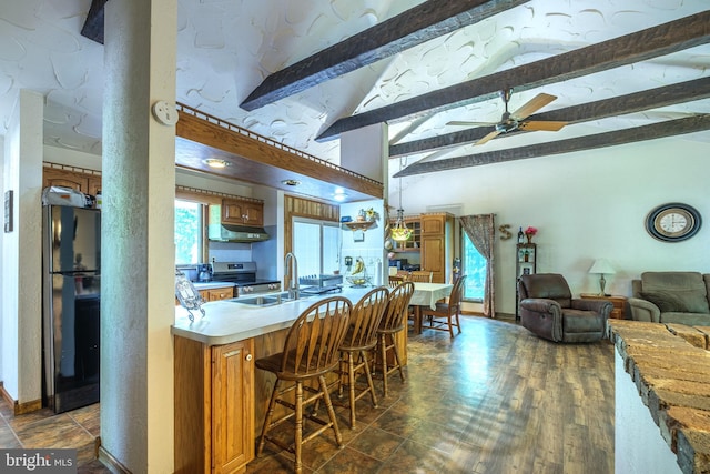 kitchen with black fridge, dark hardwood / wood-style flooring, sink, a kitchen breakfast bar, and beamed ceiling