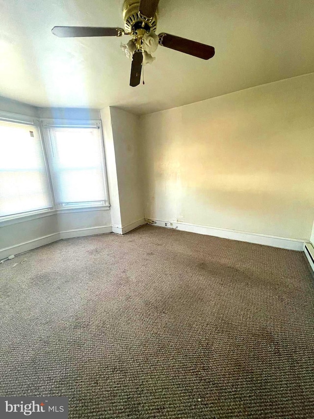 carpeted spare room featuring ceiling fan