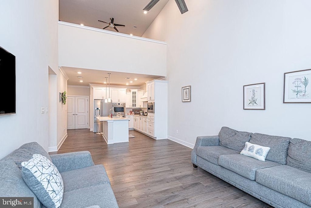 living room featuring hardwood / wood-style flooring, high vaulted ceiling, and ceiling fan