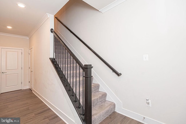 stairway with hardwood / wood-style flooring and crown molding