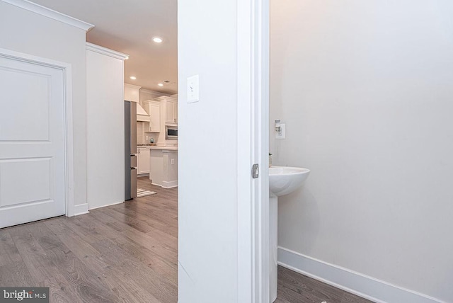 bathroom featuring wood-type flooring and crown molding