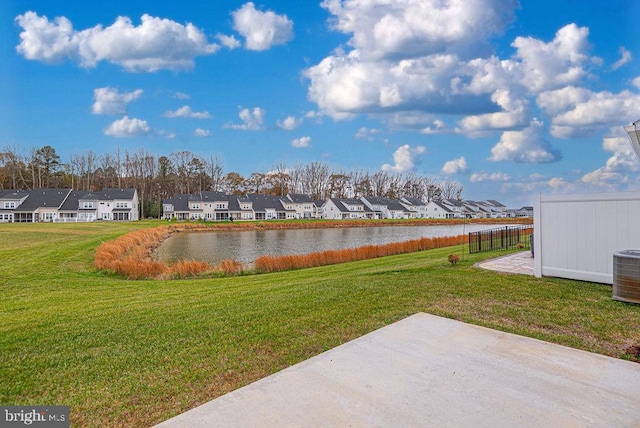 view of yard featuring a water view, central air condition unit, and a patio