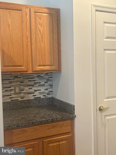 kitchen featuring dark stone counters and backsplash