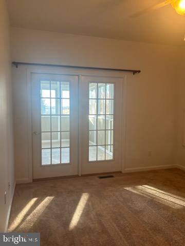 doorway featuring french doors, carpet floors, and ceiling fan