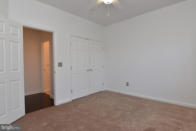 unfurnished bedroom with ceiling fan, dark colored carpet, and a closet