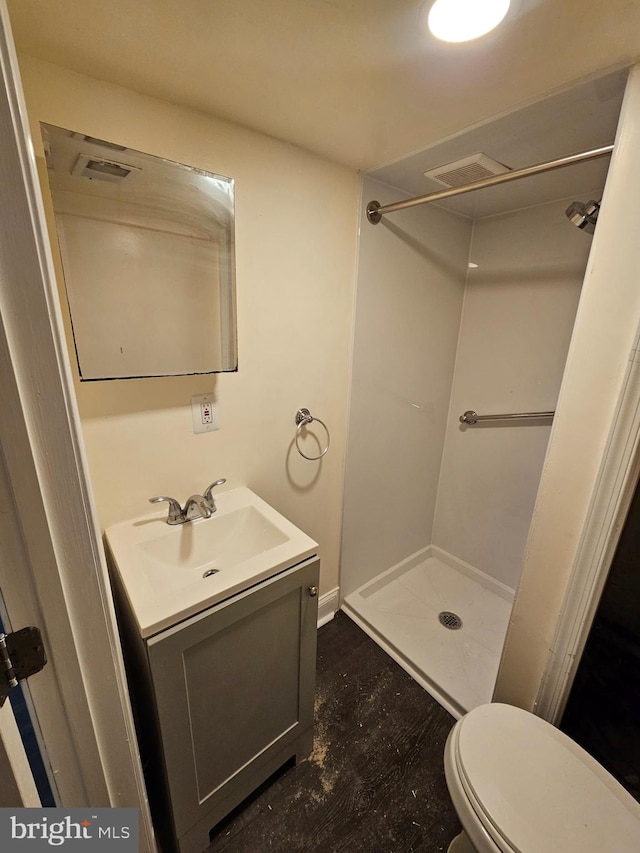 bathroom featuring vanity, toilet, and walk in shower