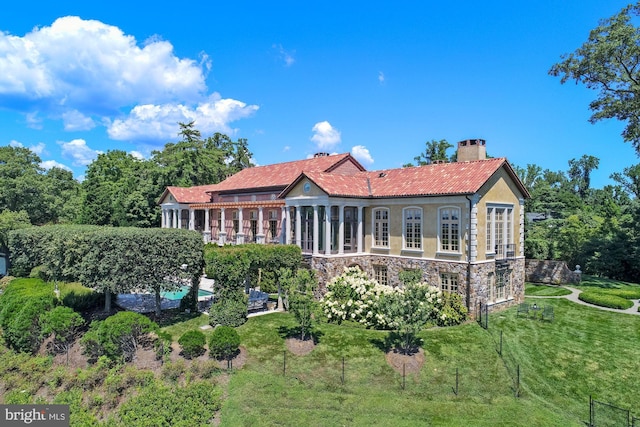 rear view of house featuring a yard