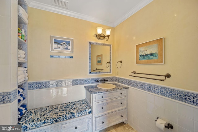 bathroom featuring tile walls, vanity, and crown molding