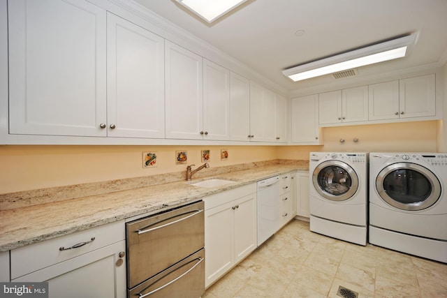 laundry area with cabinets, sink, crown molding, and washer and dryer