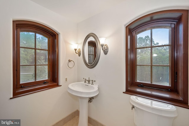 bathroom with toilet and a healthy amount of sunlight