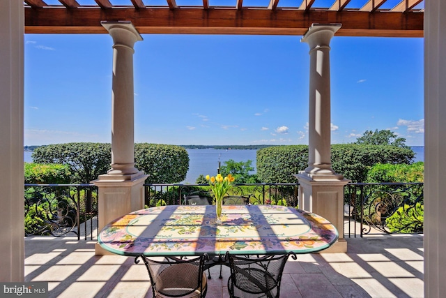 view of patio with a water view and a pergola