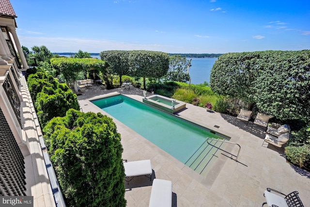 view of swimming pool featuring a water view, a patio, and an in ground hot tub