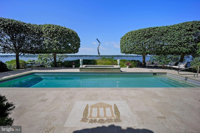 view of pool with a hot tub, a patio, and a water view