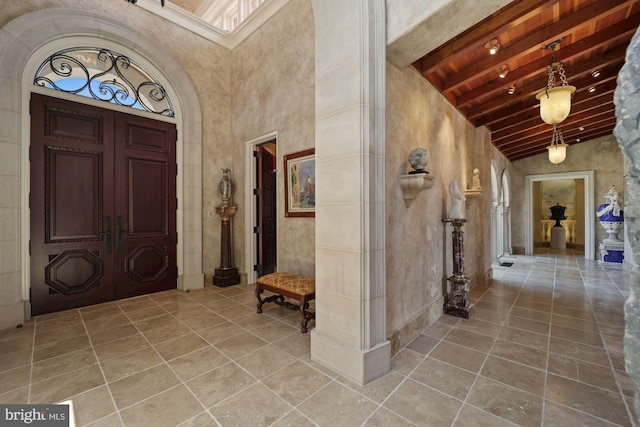 foyer entrance with french doors, high vaulted ceiling, and beamed ceiling