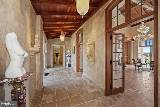 hall with french doors, an inviting chandelier, wooden ceiling, high vaulted ceiling, and beamed ceiling