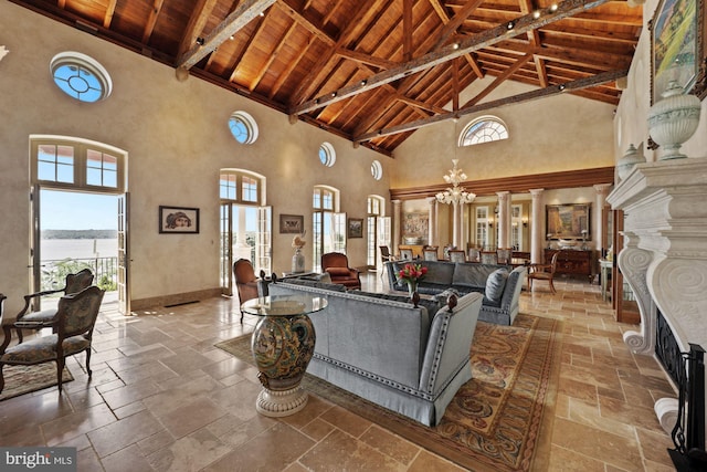 living room featuring high vaulted ceiling, beamed ceiling, wooden ceiling, and an inviting chandelier