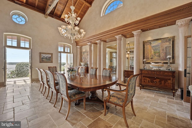 dining room with decorative columns, wooden ceiling, a healthy amount of sunlight, and a towering ceiling