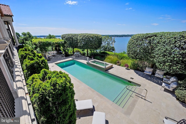 view of pool featuring a water view, an in ground hot tub, and a patio area