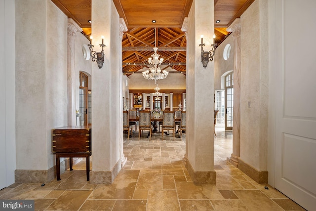 hallway featuring a chandelier, wooden ceiling, and a towering ceiling