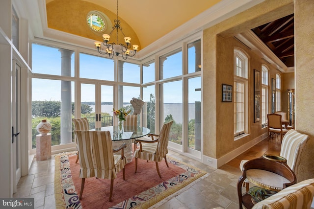 sunroom / solarium featuring a water view and a notable chandelier