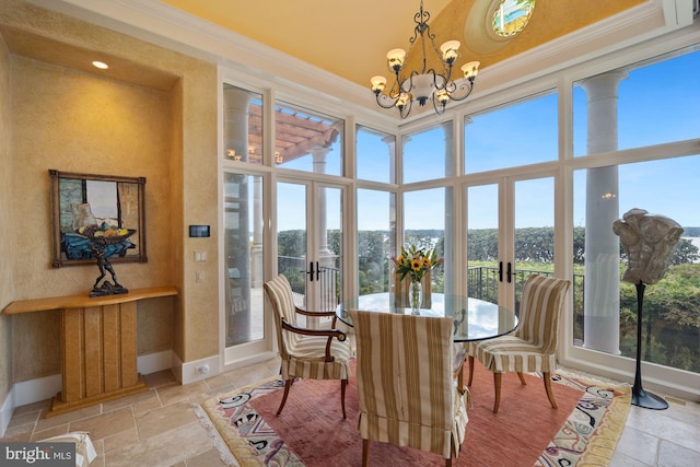 dining space featuring a wealth of natural light, a chandelier, french doors, and ornamental molding