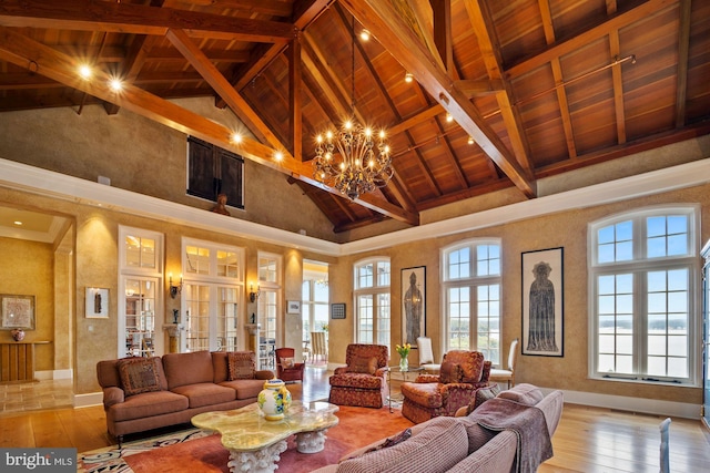 living room with beamed ceiling, plenty of natural light, light wood-type flooring, and high vaulted ceiling