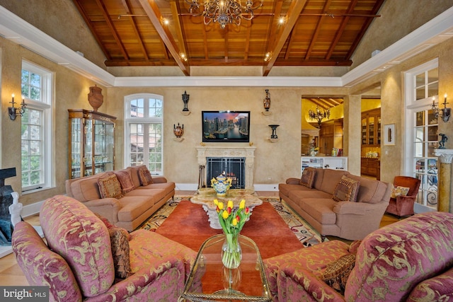 living room with beam ceiling, an inviting chandelier, high vaulted ceiling, wood ceiling, and a high end fireplace