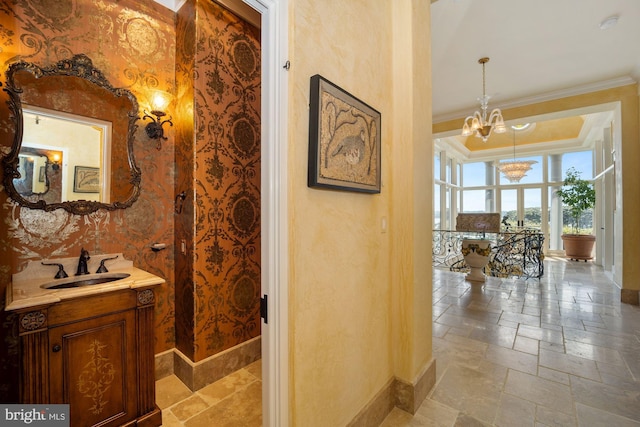 bathroom with vanity, a chandelier, and crown molding